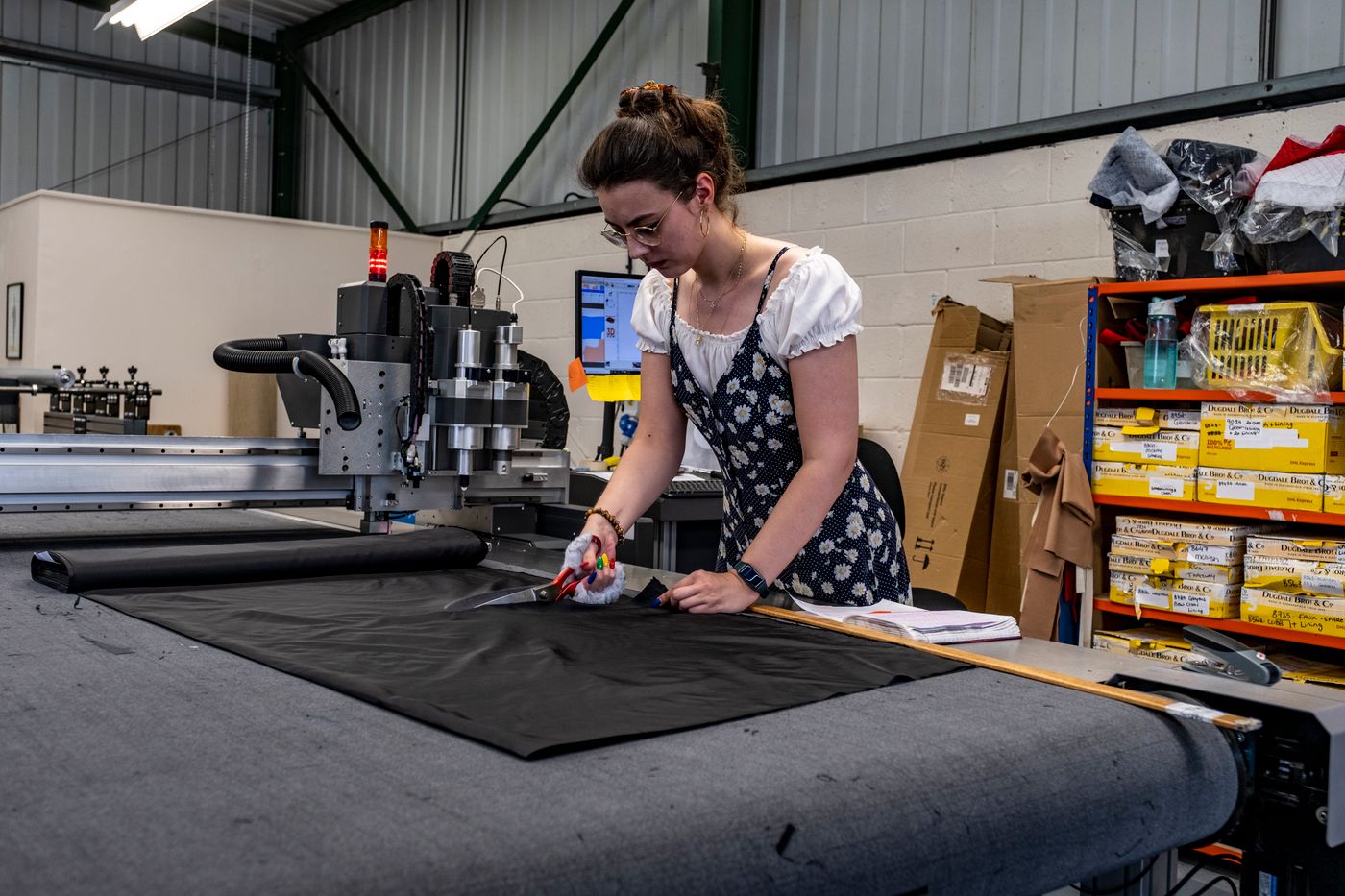 A worker cutting fabric on a workshop table; stock photograph by Mick Latter